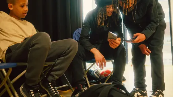 Photograph of three teenagers using their phones.