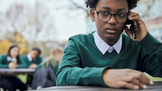 Photograph of a young boy on their phone.