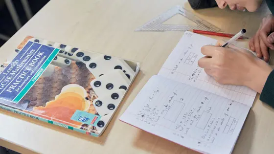 A child writing in an exercise book.