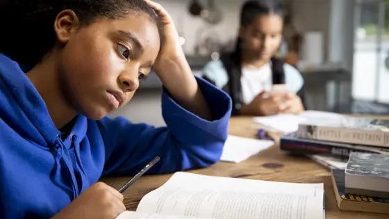 A young person sat a table with an open book