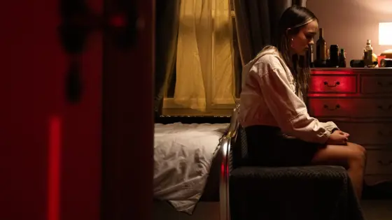 Teenage girl sat on a bed
