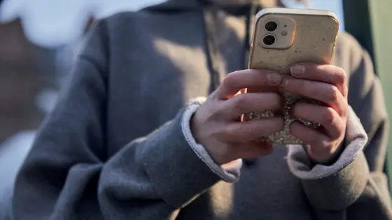 Photograph of a child using a mobile phone.