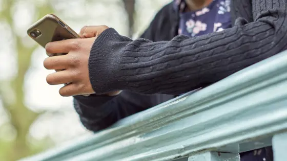 Photograph of a child using their mobile phone.