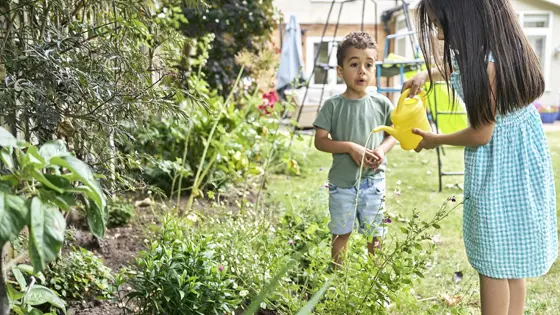 A young boy and girl playing in a garden