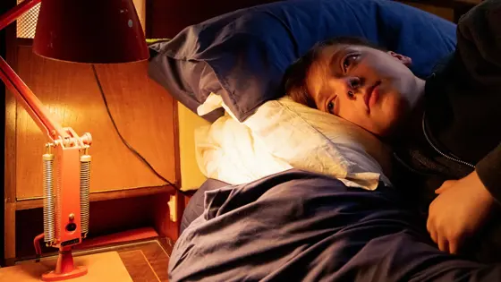 Teenage boy lying on a bed