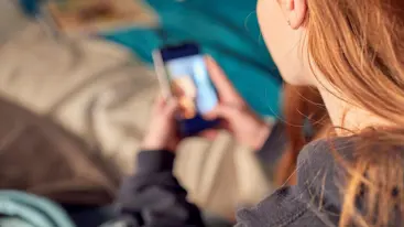 Photograph of a girl using her phone.